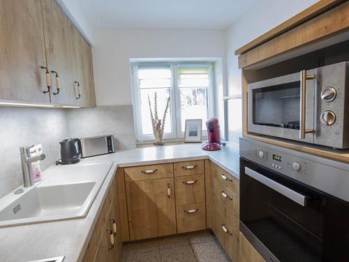 a kitchen with a sink and a microwave at Am 12er in Mittelberg