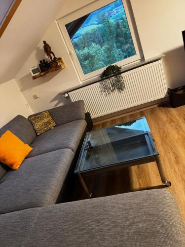 a living room with a couch and a large window at Am 12er in Mittelberg