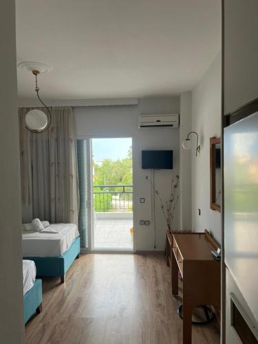 a hotel room with a bed and a desk and a bedroom at Hotel Athina in Asprovalta