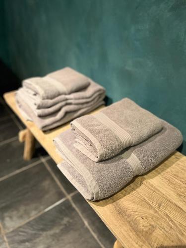 a pile of towels sitting on a wooden table at La Très Petite Tour in Nivelles