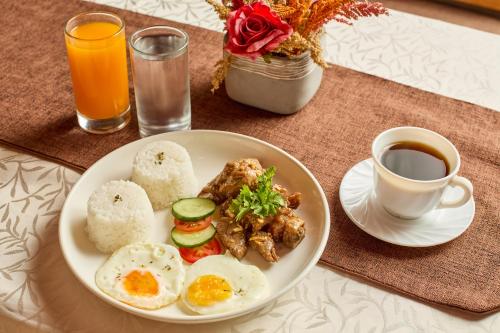 a plate of food with eggs and meat and a cup of coffee at Go Hotels Plus Bacolod - Newly Renovated in Bacolod