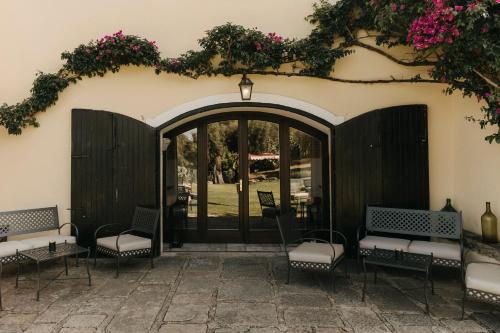 a patio with chairs and a door with flowers at Casa Qafiz 
