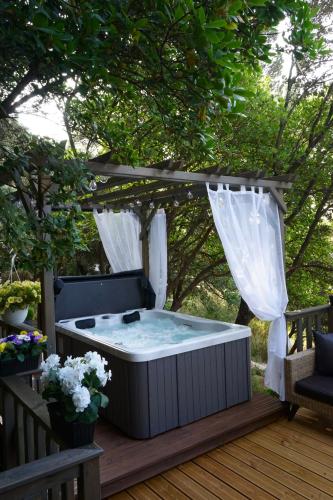a hot tub on a deck with a gazebo at Logements insolites du Domaine de la Tuilière in Carnoules