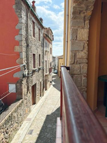 a narrow street with buildings and a fence at Apartamentos Cal Ratero in Maçanet de Cabrenys
