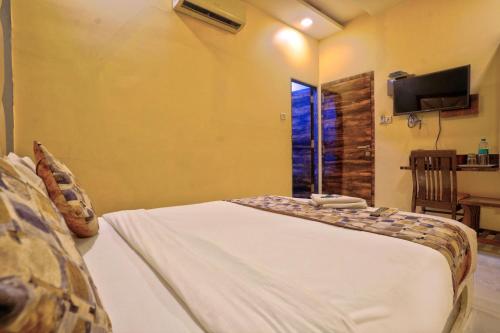 a bedroom with a bed and a tv and a window at Hotel Magnet TERMINAL-2 in Mumbai