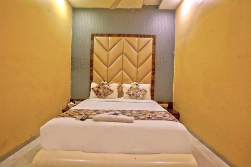 a bedroom with a large white bed with pillows at Hotel Magnet TERMINAL-2 in Mumbai
