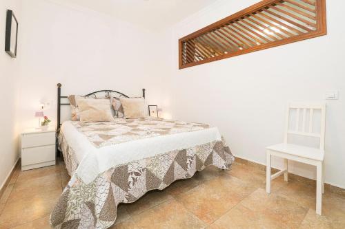 a white bedroom with a bed and a table at Casa Algodon in Chiclana de la Frontera