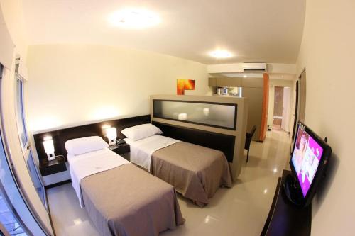 a hotel room with two beds and a flat screen tv at Lecer Apart in Buenos Aires