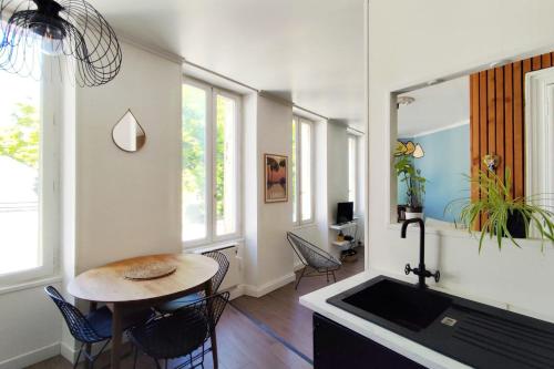 une cuisine avec une table et des chaises dans une pièce dans l'établissement Bright 45m near the Jardin Public, à Bordeaux