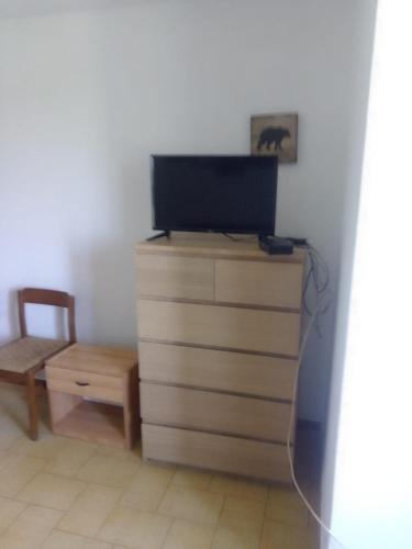 a television on top of a dresser with a chair at Panoramica in Cretone