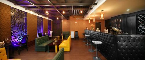 a restaurant with a bar with green and yellow chairs at The Cox Today Limited in Cox's Bazar