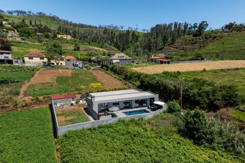 eine Luftaufnahme eines Hauses mit Swimmingpool in der Unterkunft Vila da Ponta do Pargo by An Island Apart in Ponta do Pargo