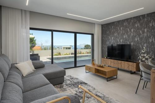 ein Wohnzimmer mit Sofa und Fernseher in der Unterkunft Vila da Ponta do Pargo by An Island Apart in Ponta do Pargo