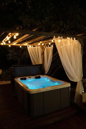 a hot tub under a canopy with lights at Logements insolites du Domaine de la Tuilière in Carnoules