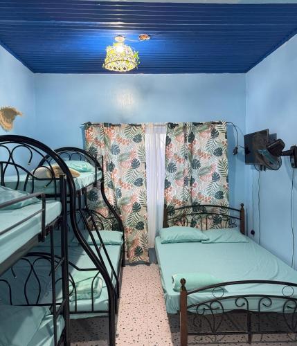 a room with two bunk beds and a blue ceiling at La Evangs Beach Resort Taal in San Luis