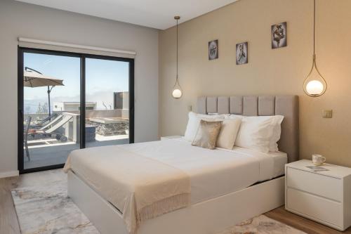 a bedroom with a large bed and a balcony at Vila da Ponta do Pargo by An Island Apart in Ponta do Pargo