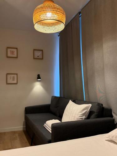 a living room with a black couch and a chandelier at Central Studios in The Hague