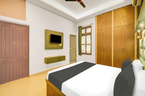 a bedroom with a bed and a tv and a door at Hotel O Sunrise in Dānāpur