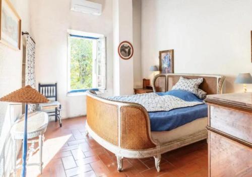 une chambre avec un lit, une table et une fenêtre dans l'établissement Maison Traditionnelle Catalane avec terrain de tennis et piscine, à Palau-del-Vidre