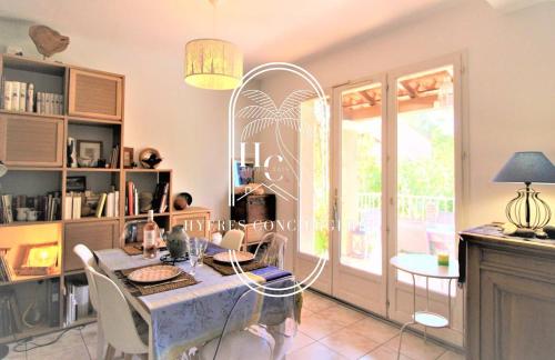 une salle à manger avec une table et des chaises et une fenêtre dans l'établissement L'écrin Costebelle Villa T4 Plage Wifi Clim By HC, à Hyères