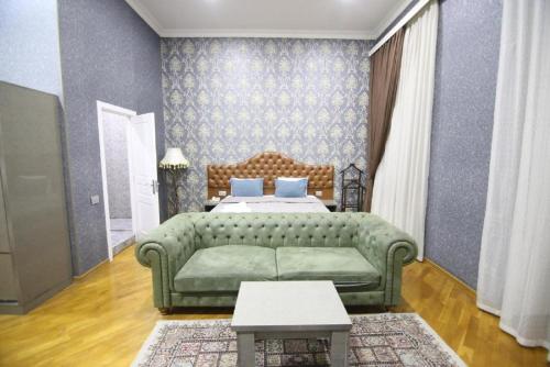 a living room with a green couch and a bed at Prime Boutique Hotel in Baku