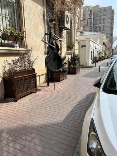 a car parked on a brick sidewalk next to a building at Prime Boutique Hotel in Baku