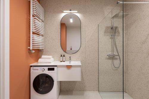 a bathroom with a washing machine and a shower at Trevi Apartments Katowice in Katowice