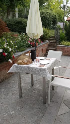 a table with a umbrella and a table with chairs at B&B Montisclari in Monchiero