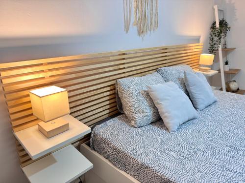 une chambre avec un lit avec une tête de lit en bois dans l'établissement Le Havre de paix Montpelliérain - terrasse et parking privé, à Montpellier