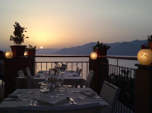 a table set for dinner on a balcony with the sunset at Stella Maris Resort in Camogli