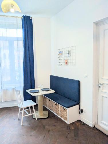a room with a blue bench and a table at Barbieux Charmant studio au pied du métro in Roubaix