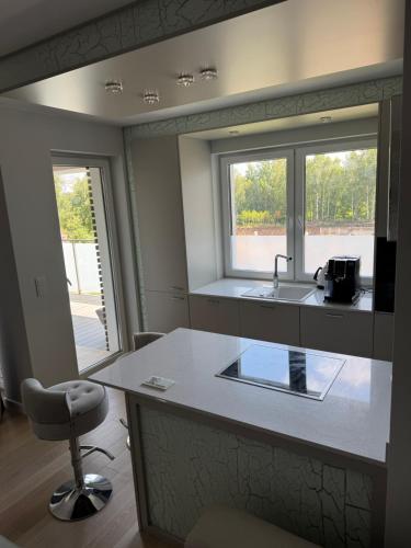 a kitchen with a counter and a sink and a window at AKOYA APARTMENT Cristal Bianco in Koszalin