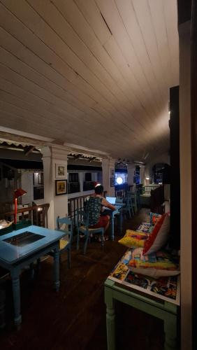a room with tables and a person sitting at a table at ArtNEST Gallery Stay , Pedlars St , Galle Fort in Galle