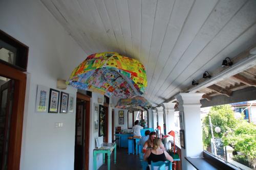 a colorful umbrella hanging from the ceiling of a building at ArtNEST Gallery Stay , Pedlars St , Galle Fort in Galle