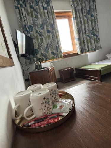 a tray with cups on a table in a room at Csíki Határ Fogadó/ Hanul Hotarul Ciucului in Bixad