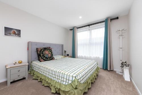 a bedroom with a bed and a window at Harborlight--Modern 2 Bedroom Townhouse in Hobsonville in Auckland