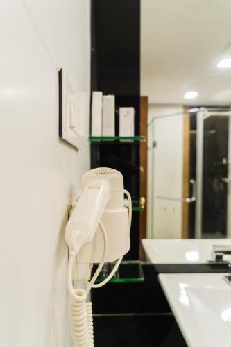 a bathroom with a phone hanging on a wall at The Mascot Hotel - A Heritage Living Experience in Trivandrum