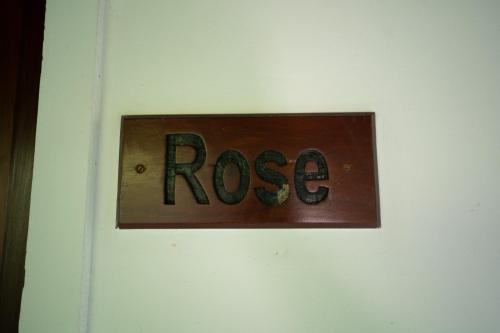 a sign that saysrosis on a white wall at Araliya Gardens Hotel in Hikkaduwa
