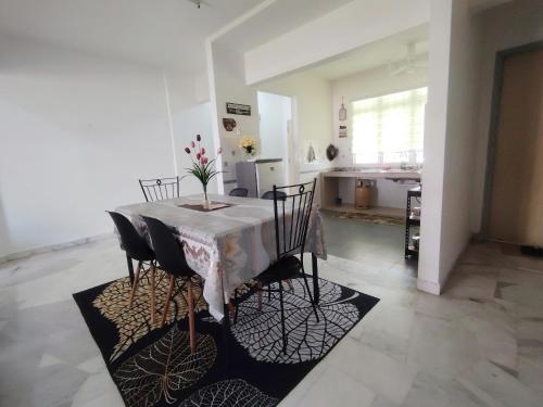 een eettafel met stoelen en een keuken bij Bayu Biru 2 Bedroom Unit Pool View Balcony in Kampong Tanah Merah