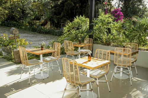 a group of tables and chairs in a garden at La Pausa Hotelbistro in Guatapé