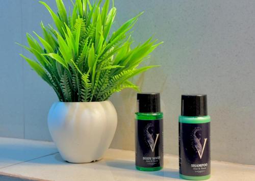 two bottles of essential oils next to a vase with a plant at Hotel Vasudevay Inn in Haridwār