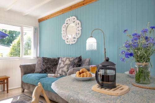 a living room with a couch and a table at Lucy Lou, charming holiday bungalow in Devon in Galmpton-on-the-Dart