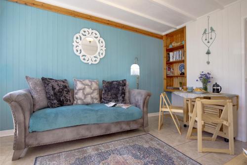 a living room with a couch and a table at Lucy Lou, charming holiday bungalow in Devon in Galmpton-on-the-Dart
