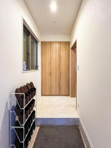 a hallway with a door to a room with wine racks at Wa Nagoya Station Business District Downtown 3-story Luxury House with Courtyard Garden 3 Bathrooms 2 Bathrooms 2 Parking Lots in Nagoya