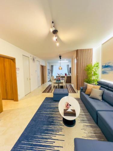 a living room with a blue couch and a table at Wa Nagoya Station Business District Downtown 3-story Luxury House with Courtyard Garden 3 Bathrooms 2 Bathrooms 2 Parking Lots in Nagoya