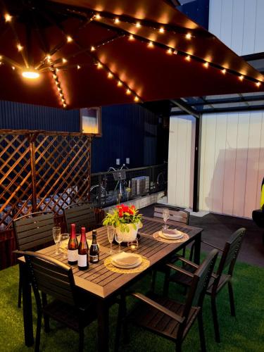 a wooden table with chairs and lights on a patio at Wa Nagoya Station Business District Downtown 3-story Luxury House with Courtyard Garden 3 Bathrooms 2 Bathrooms 2 Parking Lots in Nagoya