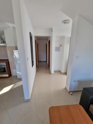a living room with white walls and a hallway at Apartman Max in Biograd na Moru