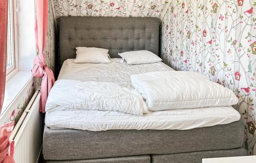 a bed with two pillows on it in a bedroom at Cozy Home In Dörarp With Sauna in Dörarp