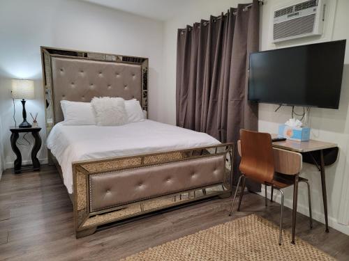 a bedroom with a bed and a desk with a television at Guest suite near La Cienega Park Beverly Hills next to LACMA La Brea Tar Pits Peterson Museum and Academy Awards Museum in Los Angeles