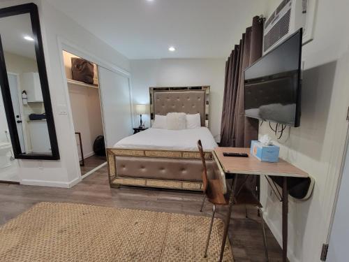 a bedroom with a bed and a television and a desk at Guest suite near La Cienega Park Beverly Hills next to LACMA La Brea Tar Pits Peterson Museum and Academy Awards Museum in Los Angeles